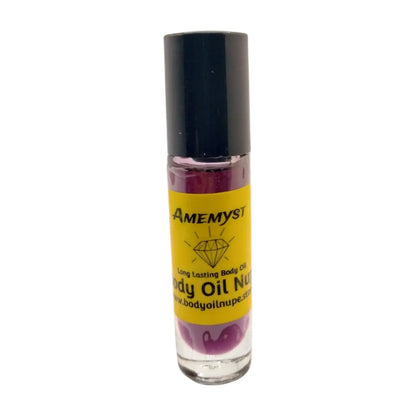 A bottle of Amemyst body oil with a purple liquid visible through the clear glass. The label includes the brand name and product description.