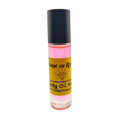 A bottle of 'Born in Roma' body oil with pink liquid visible through the clear glass and a black cap. Long-lasting fragrance from Body Oil Nupe