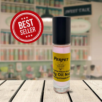 Perpet body oil by Body Oil Nupe inside of glass bottle with black top. Pink long-lasting body oil scent as best seller with faded background on top of light tan table
