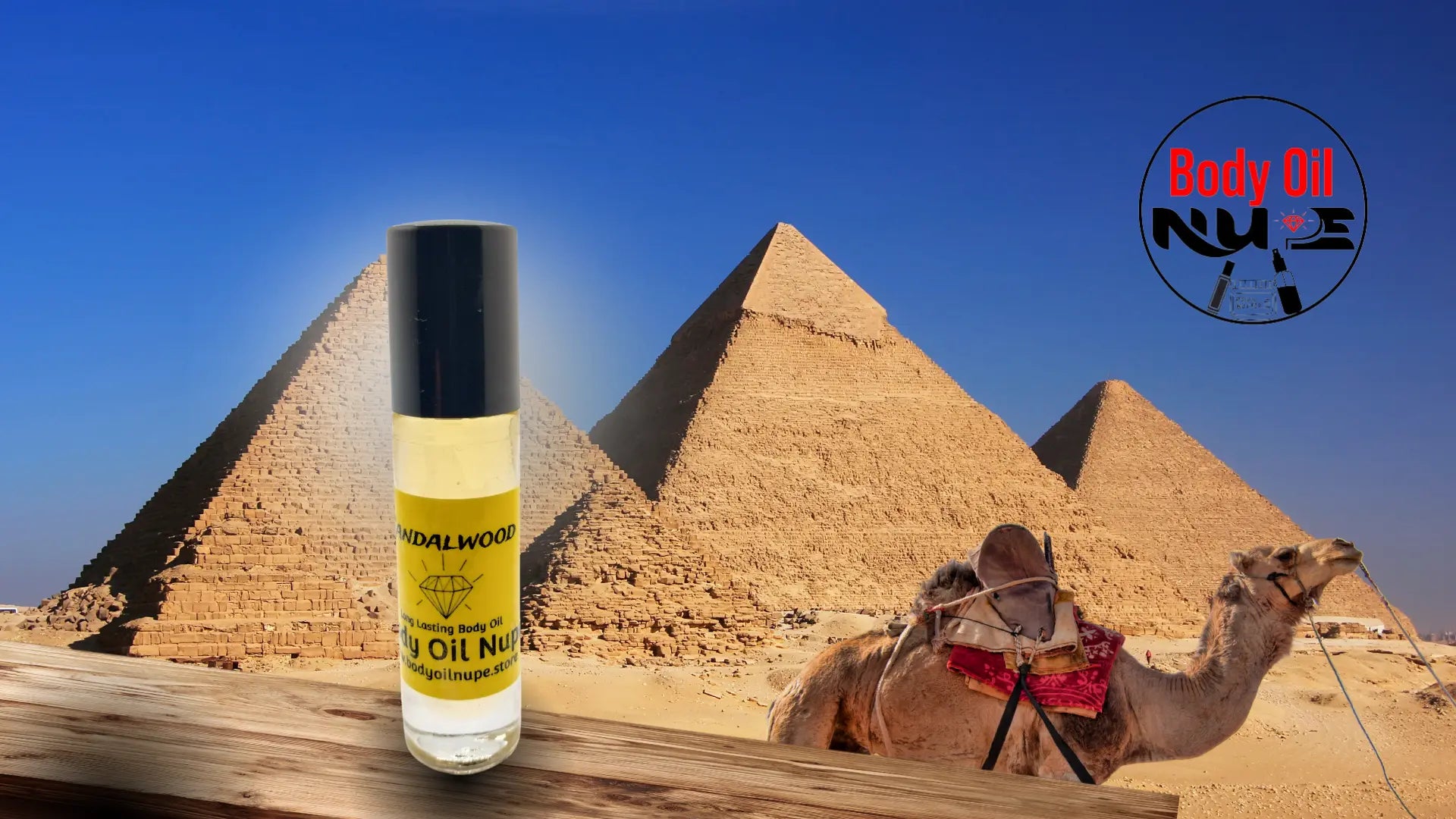 Sandalwood long‑lasting body oil displayed with the pyramids and a camel in the background to evoke exotic, warm, and luxurious fragrance notes. A yellow scent inside of glass bottle