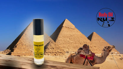 Sandalwood long‑lasting body oil displayed with the pyramids and a camel in the background to evoke exotic, warm, and luxurious fragrance notes. A yellow scent inside of glass bottle
