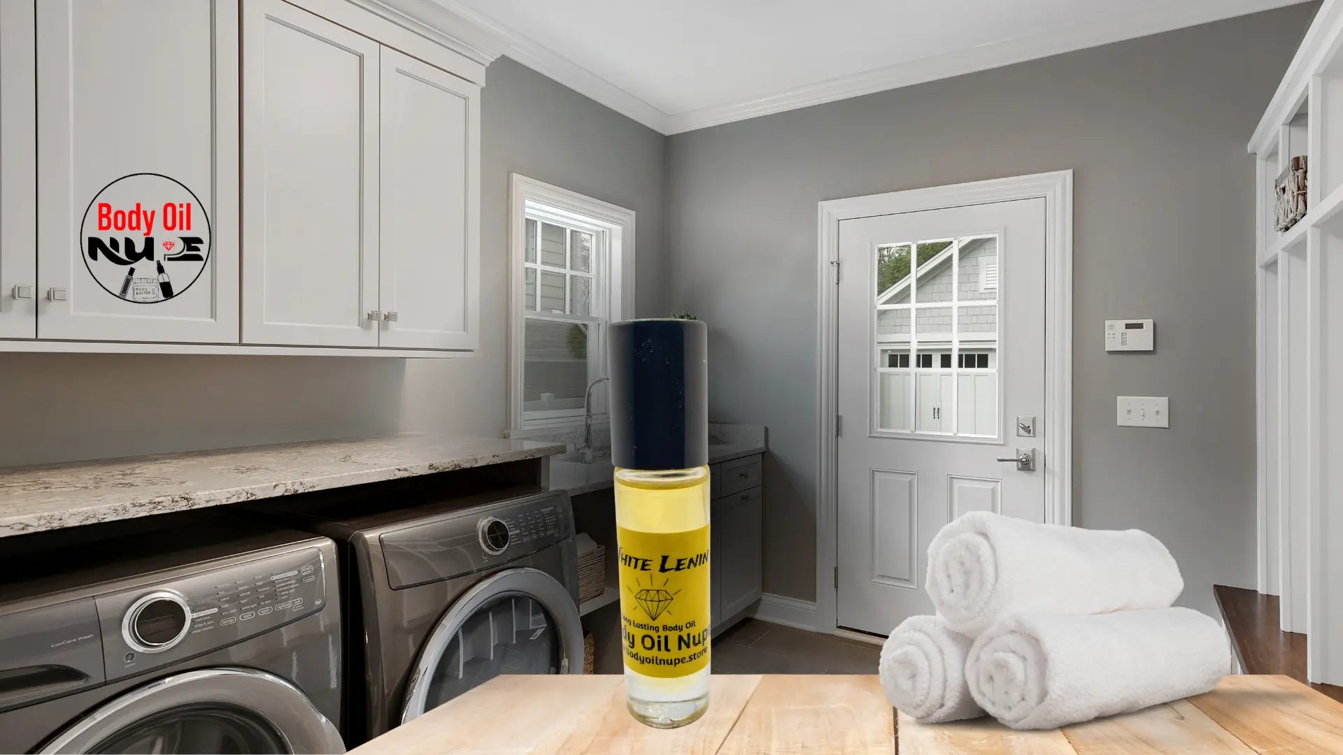 White Lenin body oil bottle displayed on a wooden surface in a modern laundry room with rolled towels, clean cabinetry, and natural light to emphasize fresh, clean fragrance notes. Long-lasting yellow fragrance oil in glass bottle