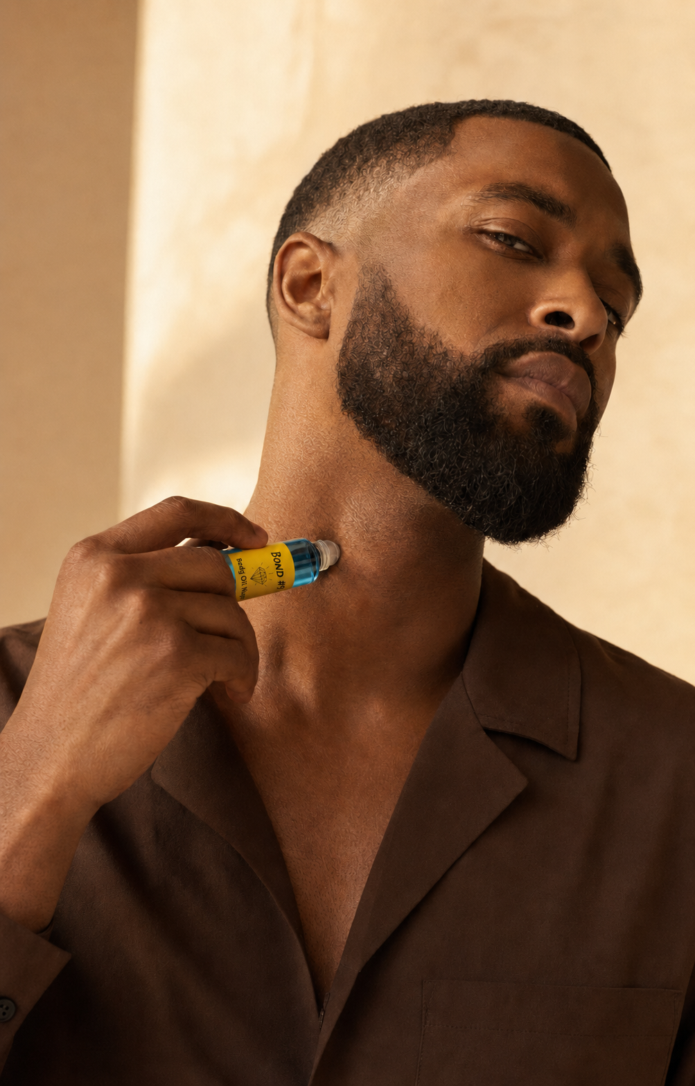 Black man applying Bond #9 Body Oil Nupe roll-on fragrance to his neck